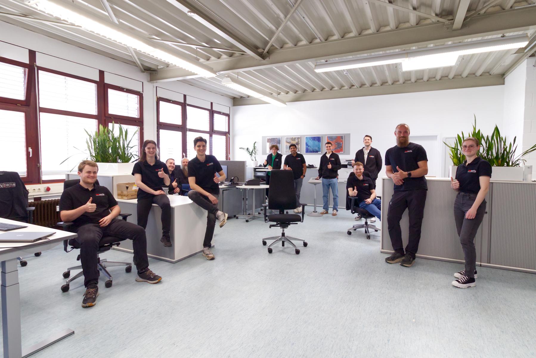 Mehrere Personen stehen und sitzen gemeinsam in einem Laborraum